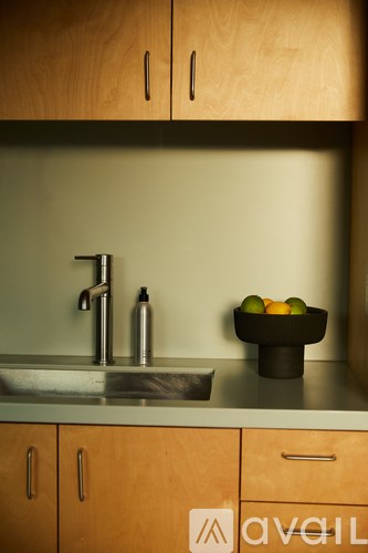 A kitchen with a sink and a bowl of fruit.