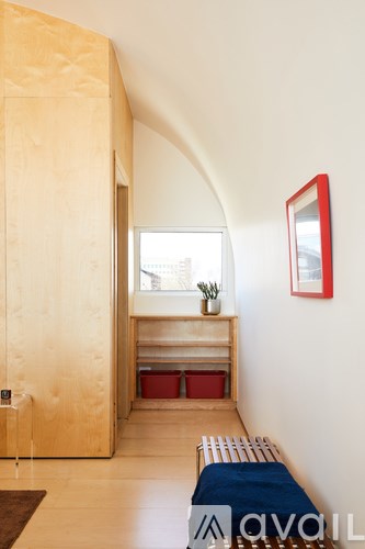 A room with a bench and a mirror on the wall.