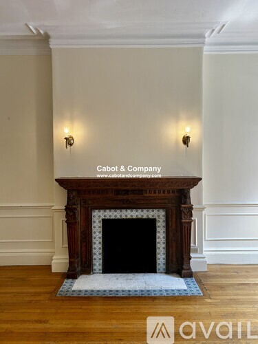 A fireplace in a room with a blue carpet in front of it.