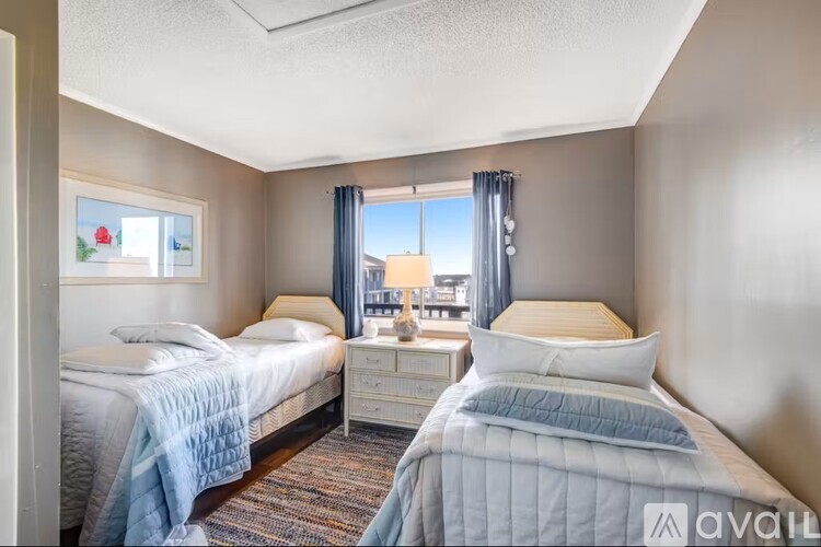 A bedroom with two beds and a window overlooking a cityscape.
