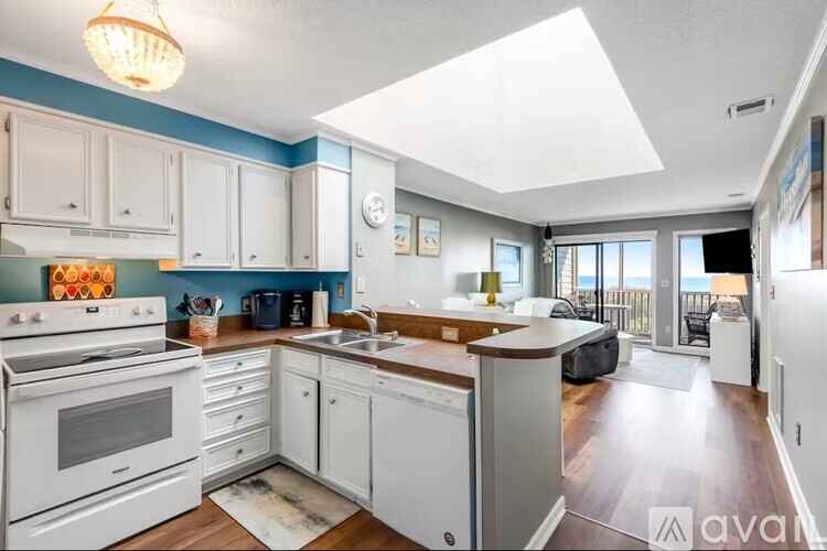 A kitchen with white cabinets and a white stove top oven.