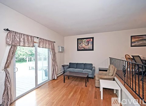 A living room with a grey couch and a wooden floor.