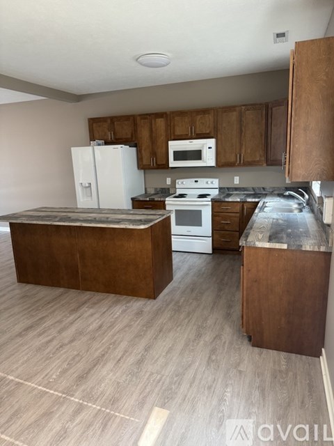 A kitchen with a white fridge, white microwave, white oven and white stove.