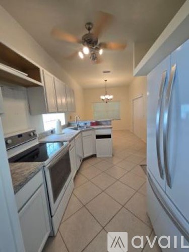A kitchen with white appliances and cabinets.