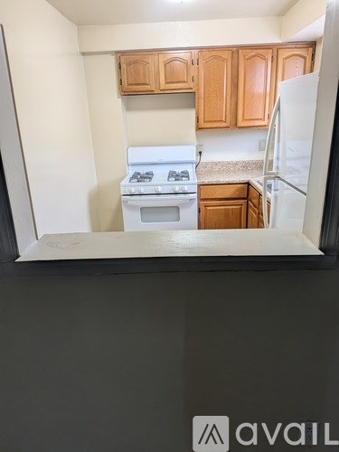 A kitchen with wooden cabinets and a white fridge.