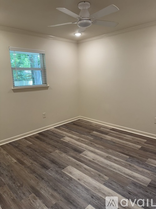 A room with a window and a ceiling fan.