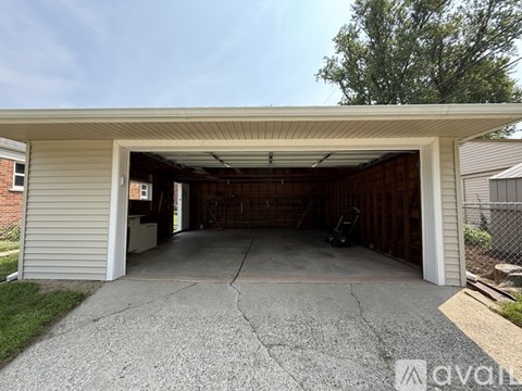 A garage with a concrete floor and a white wall.