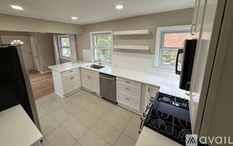 A kitchen with a black stove top and white cabinets.