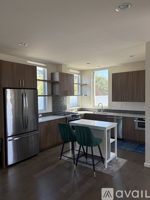 A kitchen with a table and chairs in front of a refrigerator.