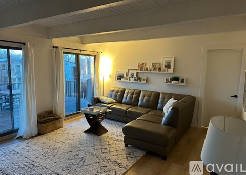 A living room with a grey sofa, a coffee table, and pictures on the wall.