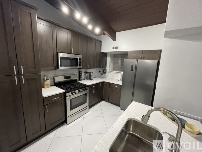 A kitchen with brown cabinets and stainless steel appliances.
