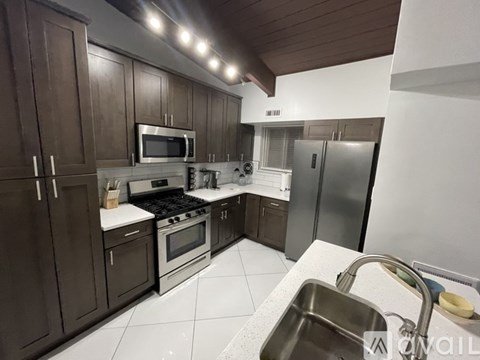 A kitchen with brown cabinets and stainless steel appliances.