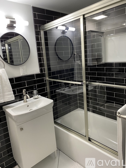A white sink in a black tiled bathroom.
