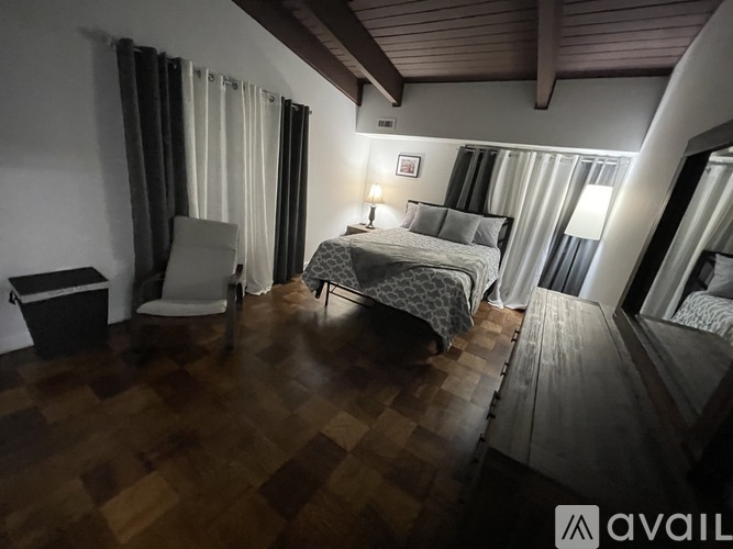 A room with two beds and a chair is available for rent.