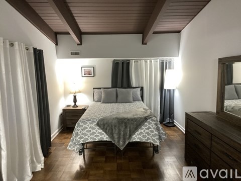 A bedroom with a bed, nightstand, and a mirror.