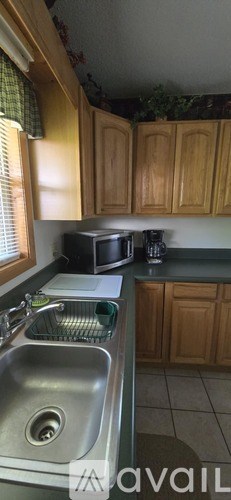 A kitchen with wooden cabinets and a stainless steel sink.