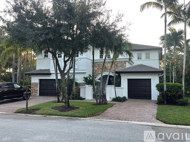 A white house with a black car parked in front.
