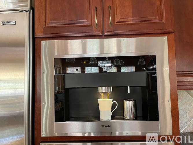 A stainless steel refrigerator with a built-in coffee machine.