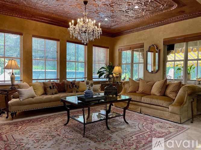 A living room with a chandelier, two couches, and a coffee table.