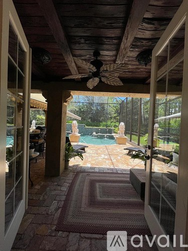 A patio with a pool and a ceiling fan.