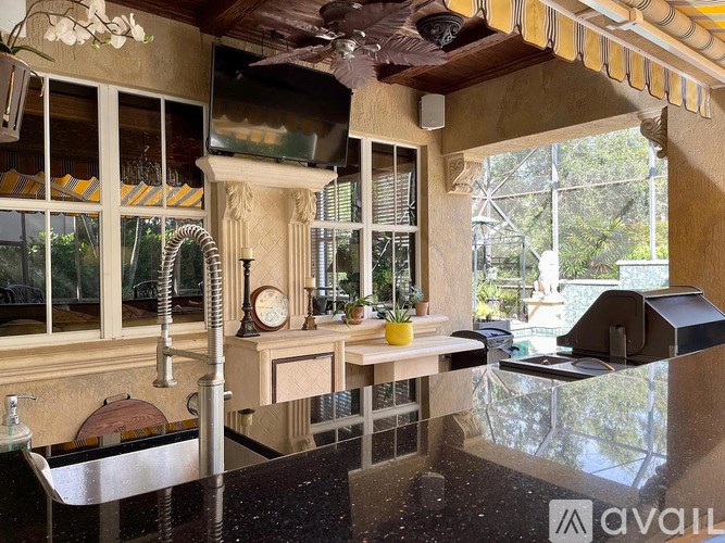 A modern kitchen with a large island and a ceiling fan.