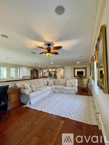 A spacious living room with a white rug and a large sectional sofa.