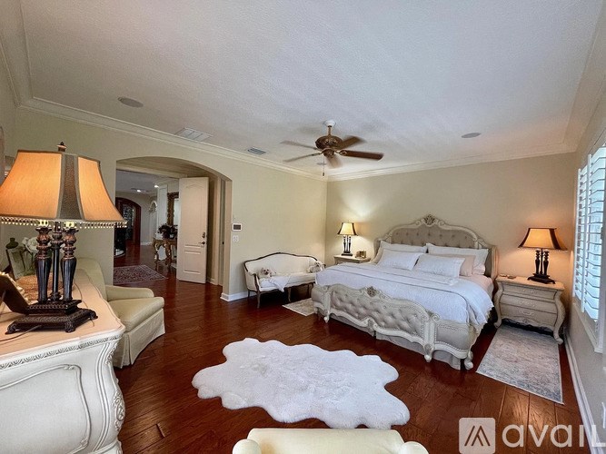 A bedroom with a large bed and a white rug on the floor.