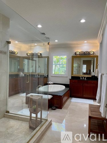 A bathroom with a glass shower stall and a bathtub.