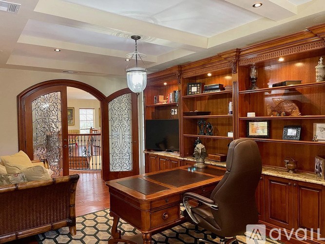 A room with a desk, chair, and bookshelf.