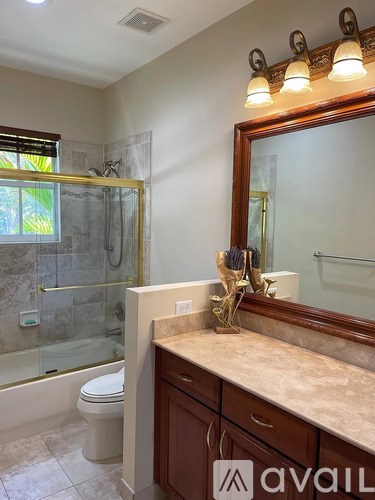 A bathroom with a marble countertop and a large mirror.