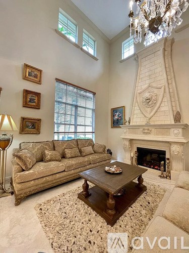 A living room with a couch, a coffee table, and a fireplace.