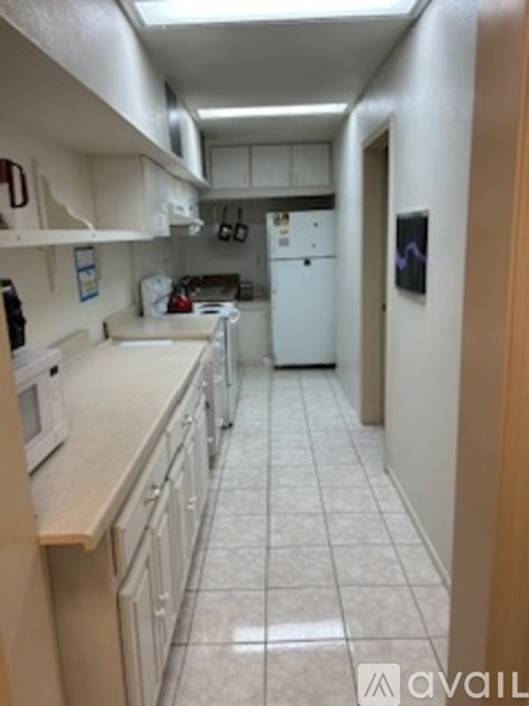 A kitchen with white appliances and white cabinets.