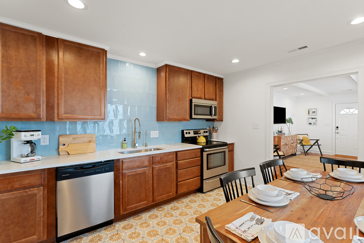 A kitchen with wooden cabinets and a dining table set for four.