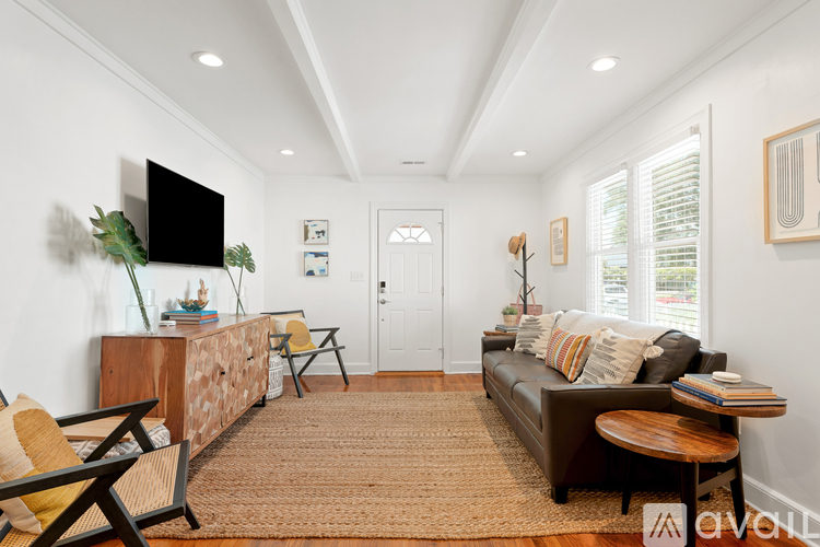 A living room with a brown rug, a brown couch, and a wooden coffee table.