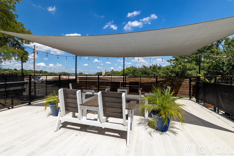 A patio with a white canopy and two chairs.