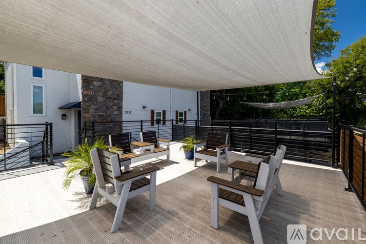 Two chairs are on a wooden deck under a white canopy.