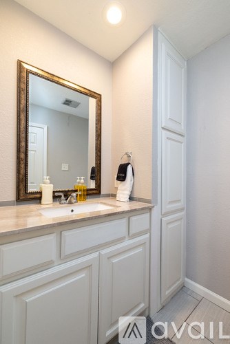 A bathroom with a sink, mirror, and toiletries.