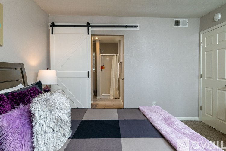 A bedroom with a bed, pillows, and a rug.