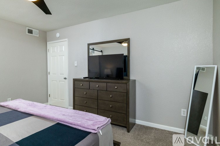 A bedroom with a bed, dresser, and mirror.