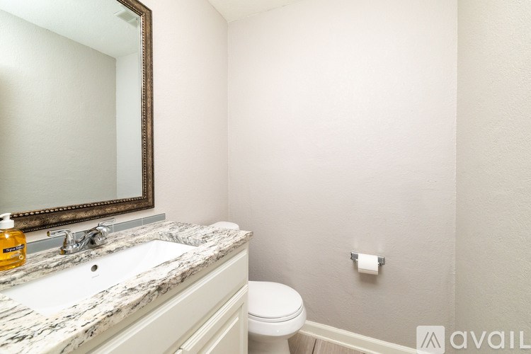 A bathroom with a marble countertop and a toilet.