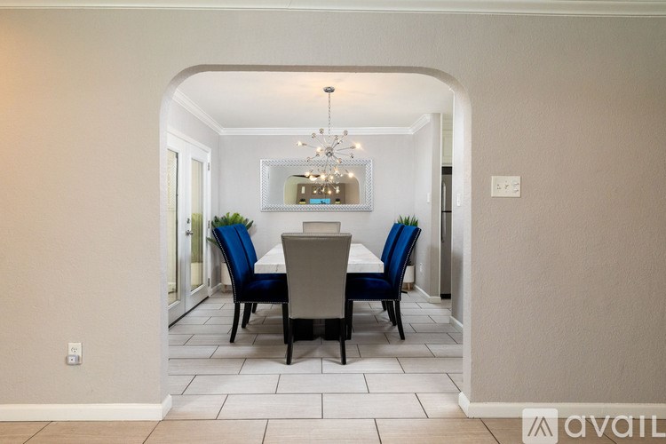 A dining room with a table and chairs.