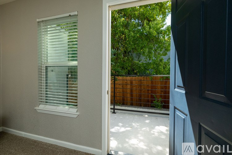 A room with a window and a door leading to a balcony.