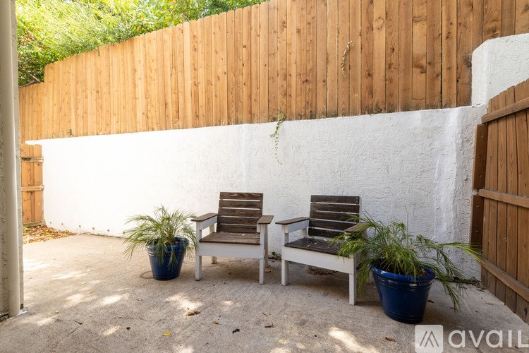 Two chairs and two potted plants on a patio.