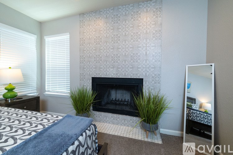A bedroom with a fireplace and a mirror.