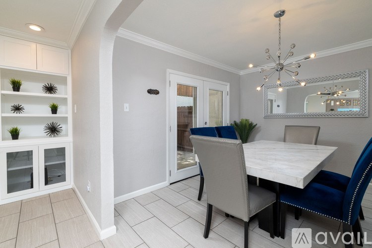 A dining room with a white table and blue chairs.