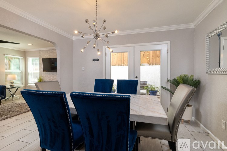 A dining room with a white table and blue chairs.