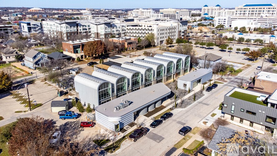 A modern building with a curved glass facade is the focal point of the image.