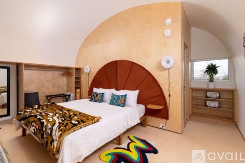 A bedroom with a large bed and a wooden headboard.