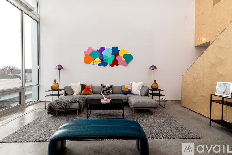 A living room with a large couch and a colorful abstract painting on the wall.