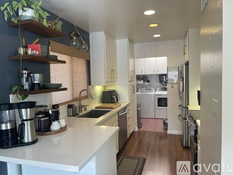 A kitchen with white countertops and stainless steel appliances.